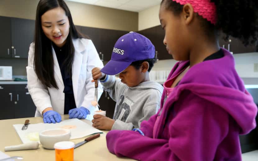 Pharmacy Technology student Victoria Ngo helps Tristin and Leah Jackson make an ointment.