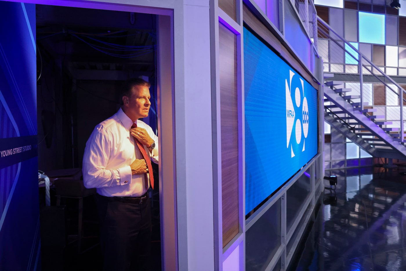 WFAA-TV chief meteorologist Pete Delkus fixes his tie ahead of his 5 PM weather forecast at...