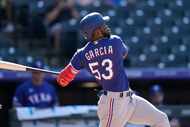 Texas Rangers' Adolis Garcia singles against Colorado Rockies relief pitcher Jhoulys Chacin...