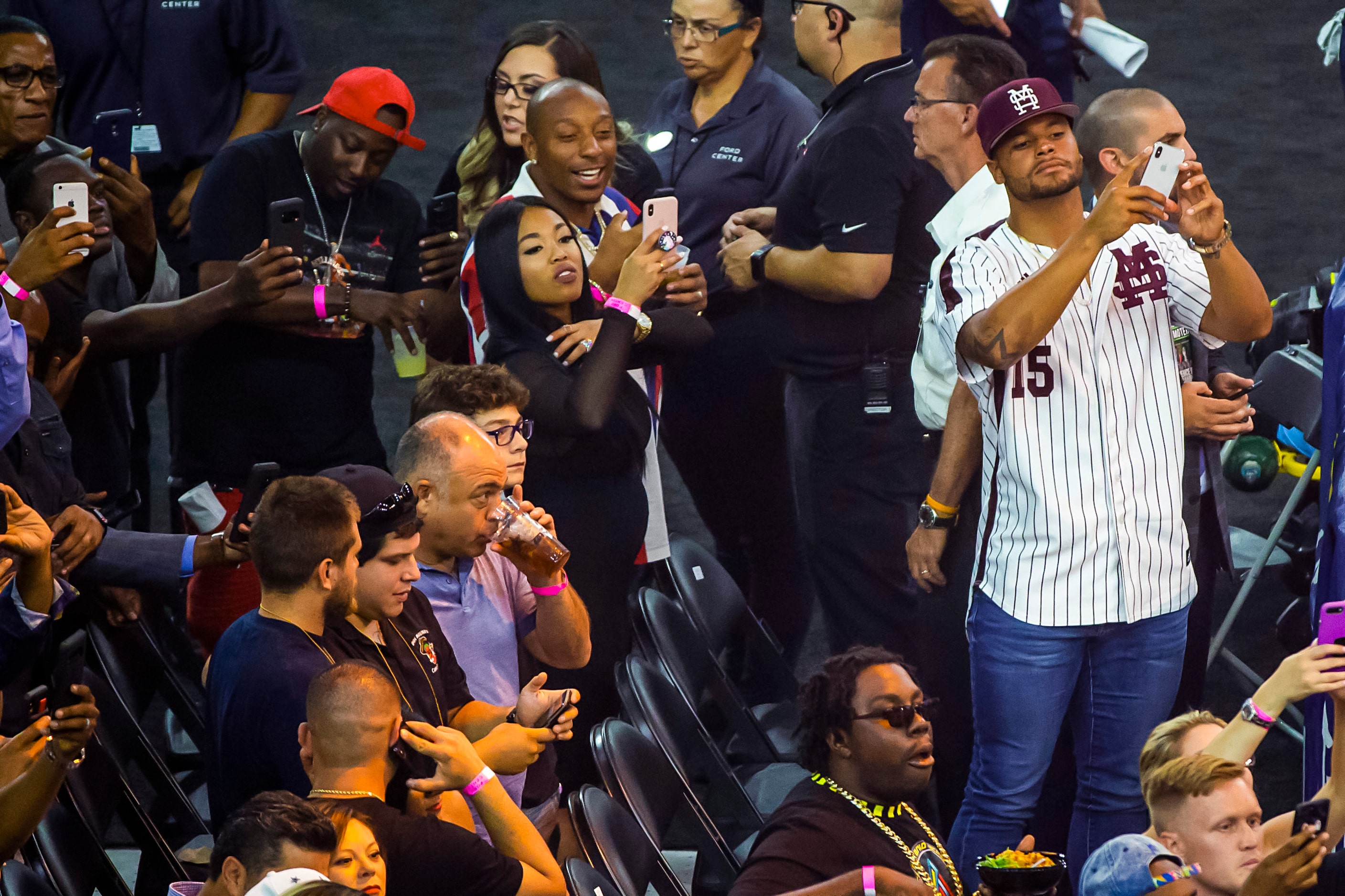 Dallas Cowboys quarterback Dak Prescott takes photos with his phone as welterweight champion...