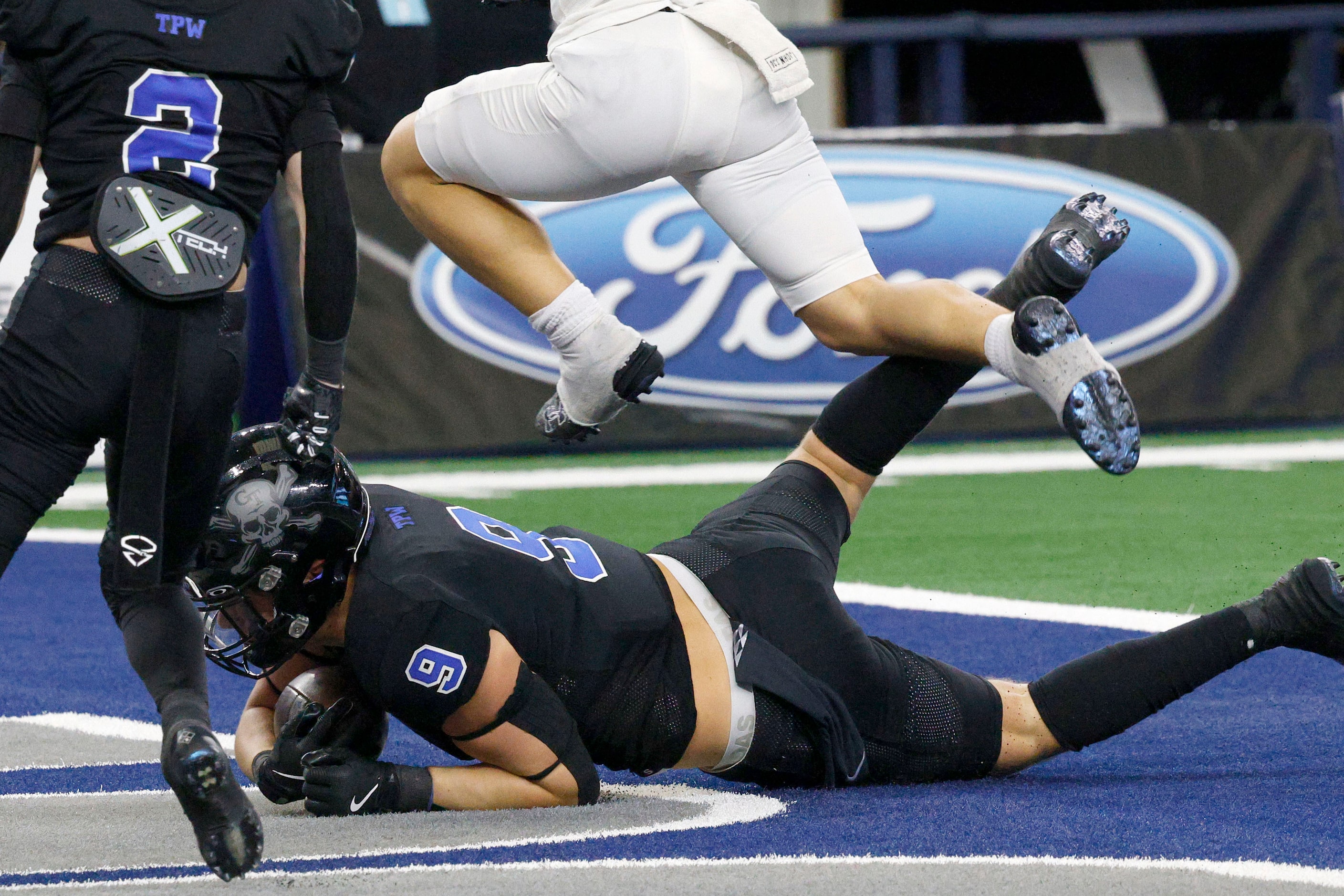 Gunter's  Cole Harpole (9) scores a touchdown as Woodville's Caleb Johnson (19) jumps over...