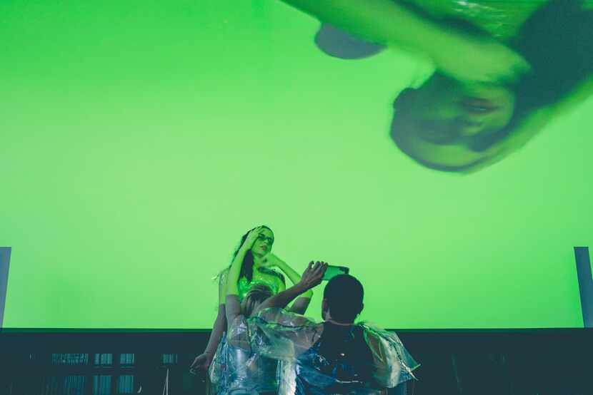 Performance artists movements are projected via live video from their phones during music...