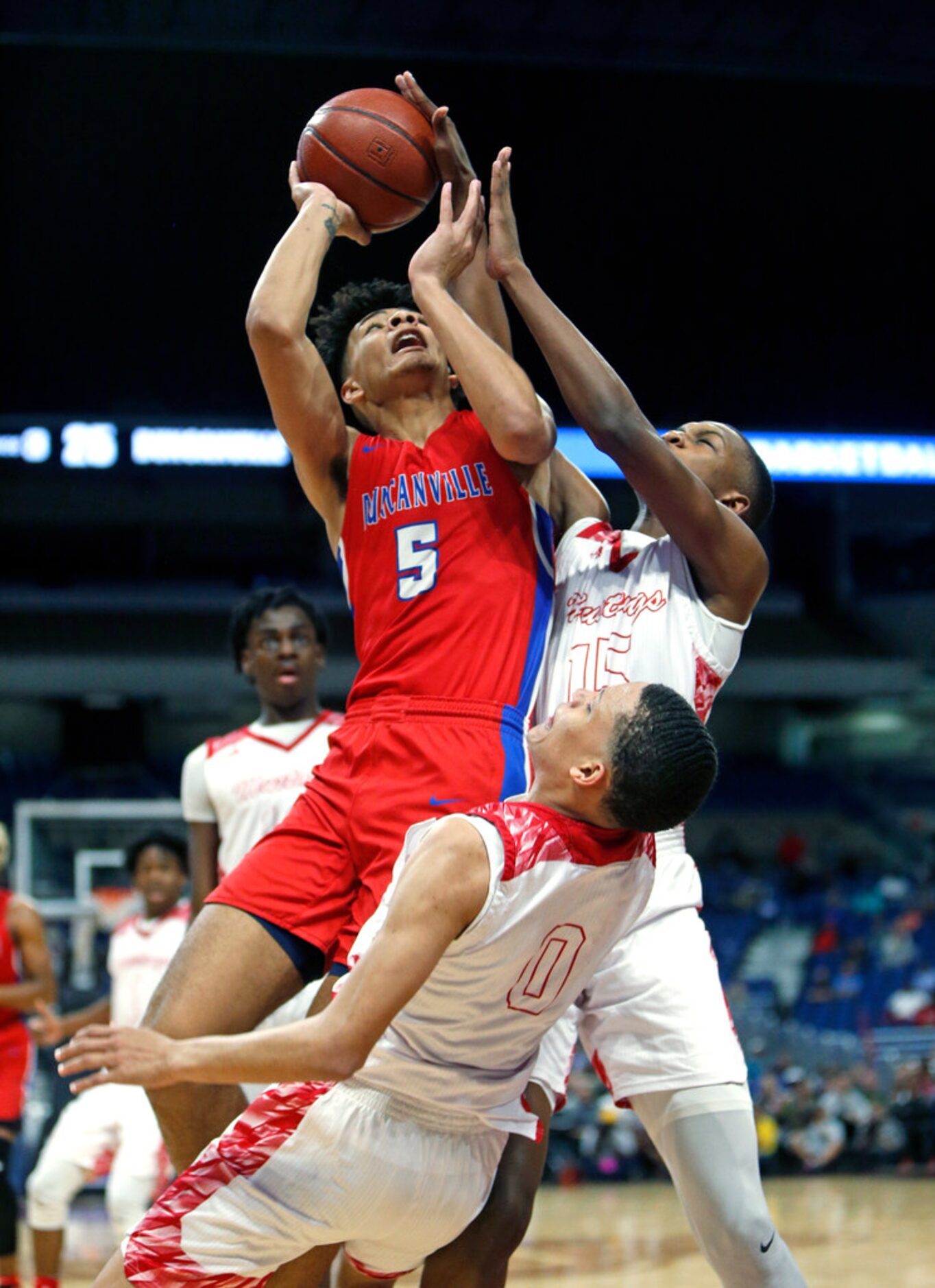 Duncanville's Micah Peavy #5 shoots over \Galena Park North's Jalen Means #15 and Galena...