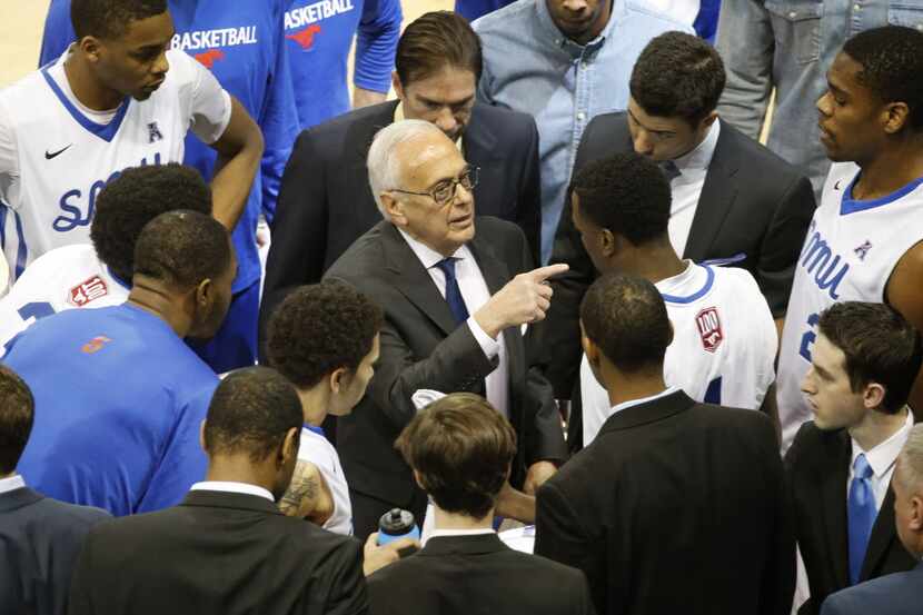SMU head coach Larry Brown talks with his team during a time out in the first half during...