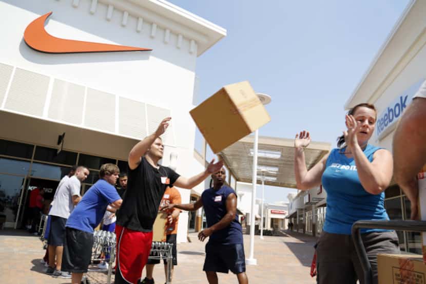 Workers stocked the Nike store at Paragon Outlets in Grand Prairie as it prepared to open.