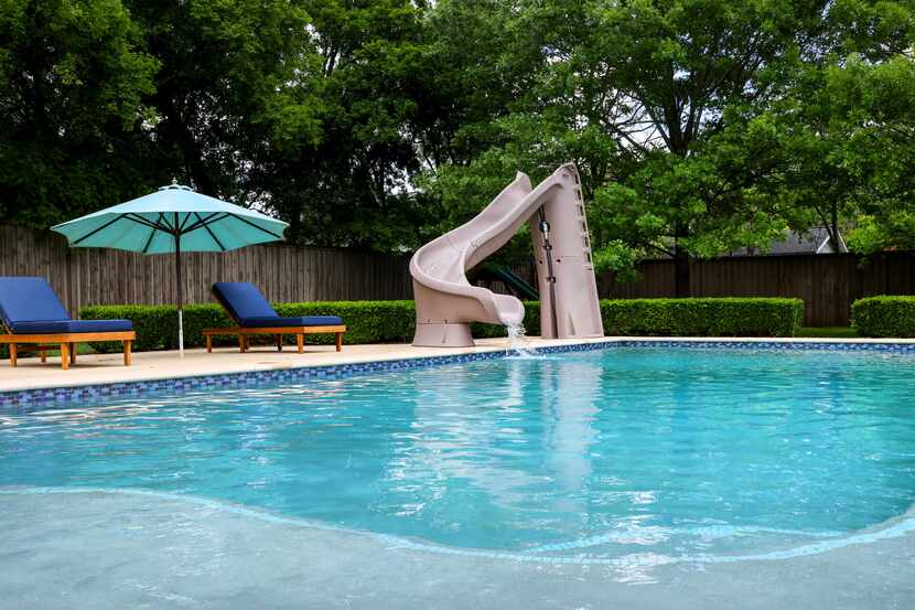 A water slide runs along the edge of Ben Kohlmann’s backyard pool in Dallas on Monday, April...