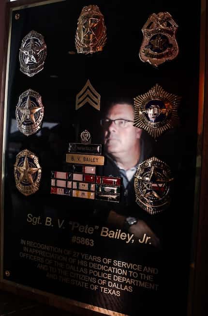 Retired Dallas police officer Pete Bailey is reflected in a plaque of his decorations. 