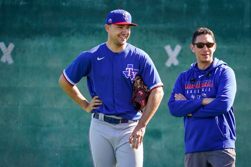 Texas Rangers pitcher Brock Burke chats with general manger Jon Daniels as they watch a...