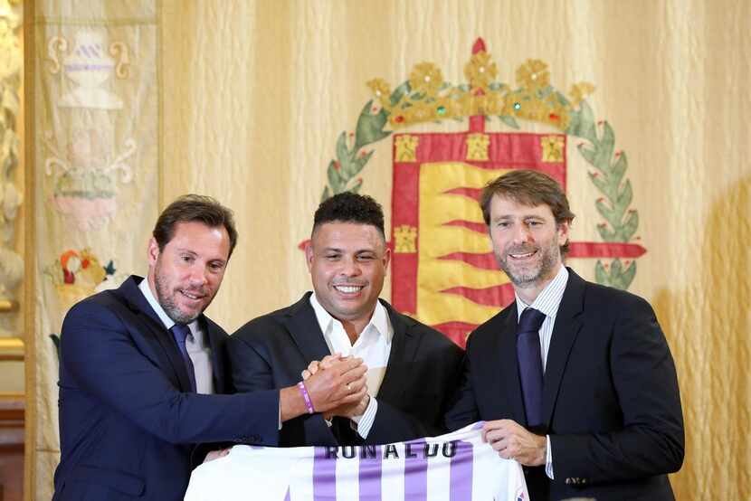 Brazilian football legend Ronaldo (C) holds a symbolic Real Valladolid jersey as he poses...