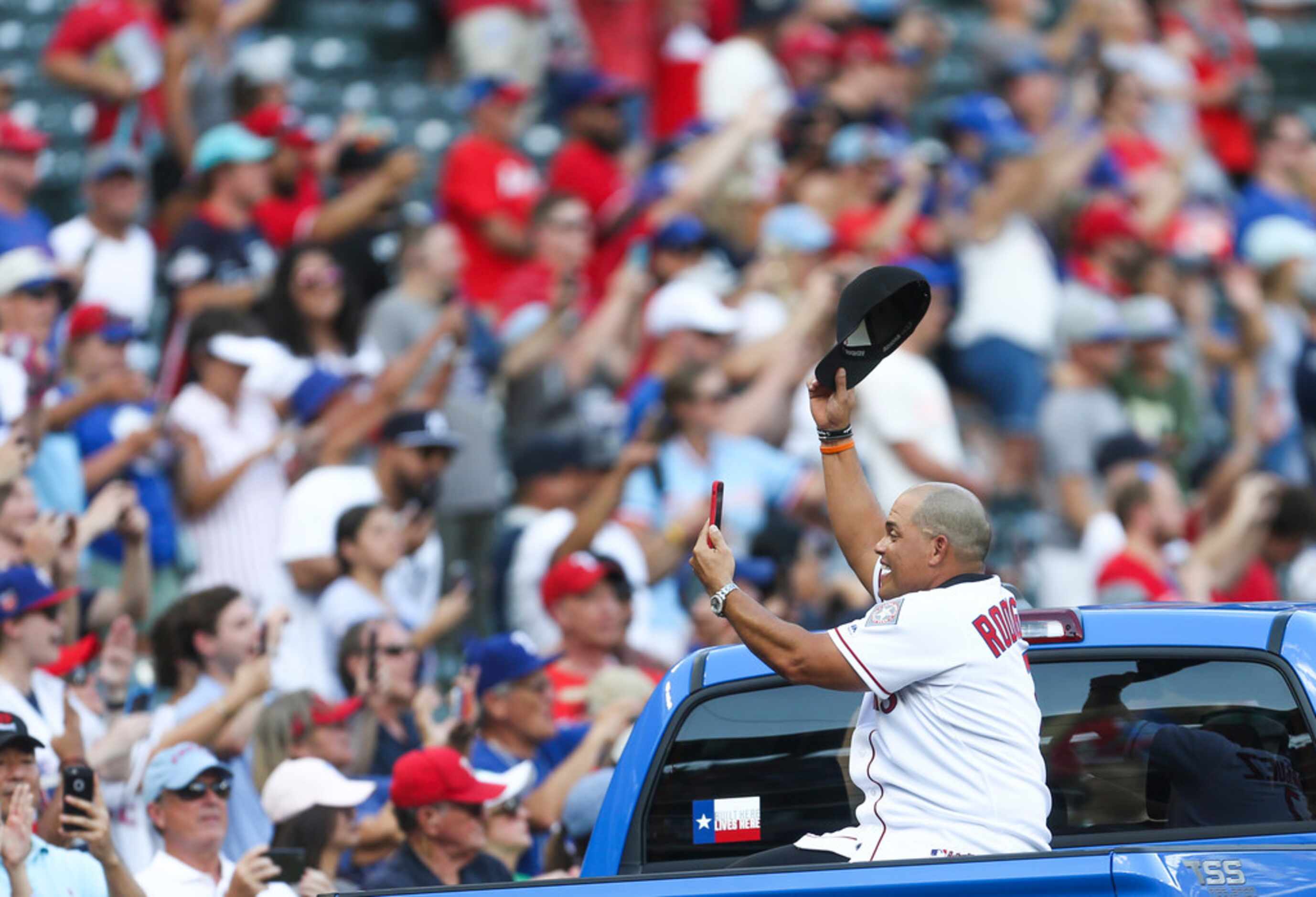 Former Texas Rangers catcher Ivan "Pudge" Rodriguez cheers on as he rides in a parade as the...