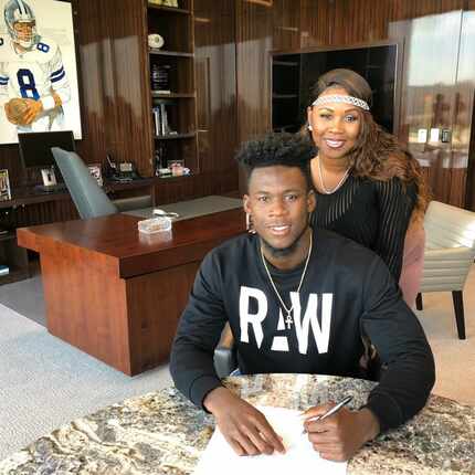 Allen Hurn signs his contract with Dallas Cowboys in Stephen Jones' office at The Star in...