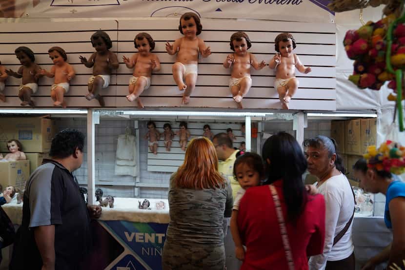 Los locales compran figuras del niño Dios en preparación para la fiesta del "Día de la...
