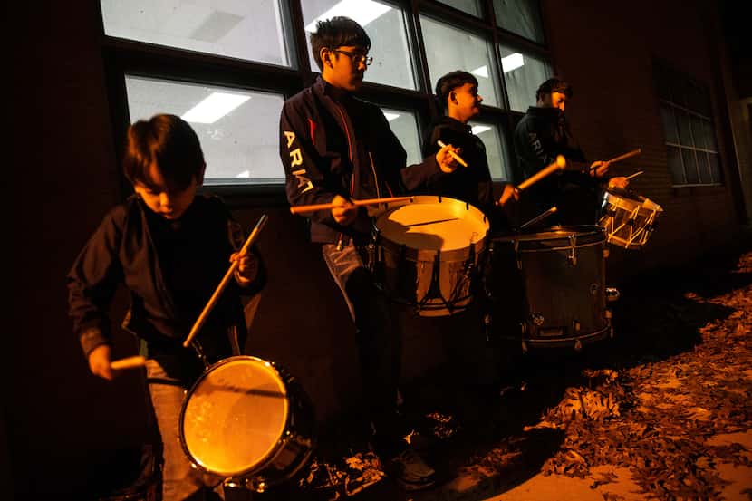 Brothers (from left) Christopher de la Sancha, 7, and Alexander Flores, 15, play the drums...