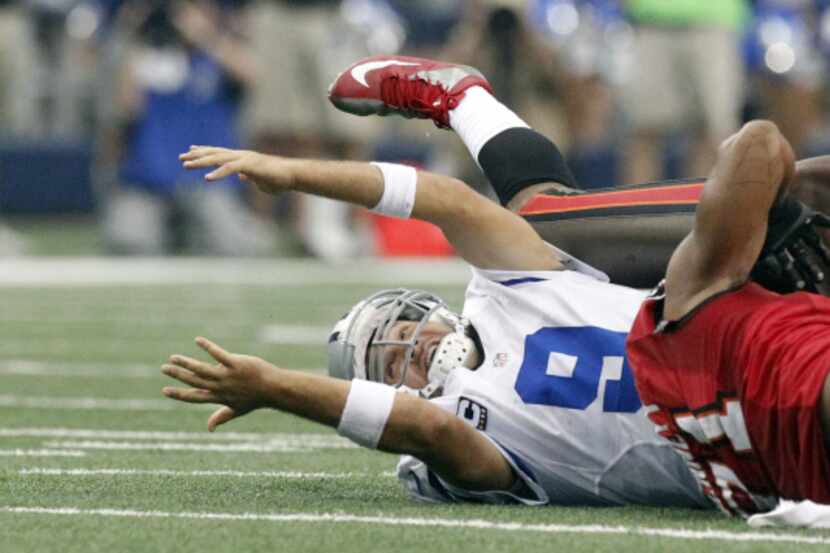 Dallas Cowboys quarterback Tony Romo (9) fumbles as he is hit by Tampa Bay Buccaneers...