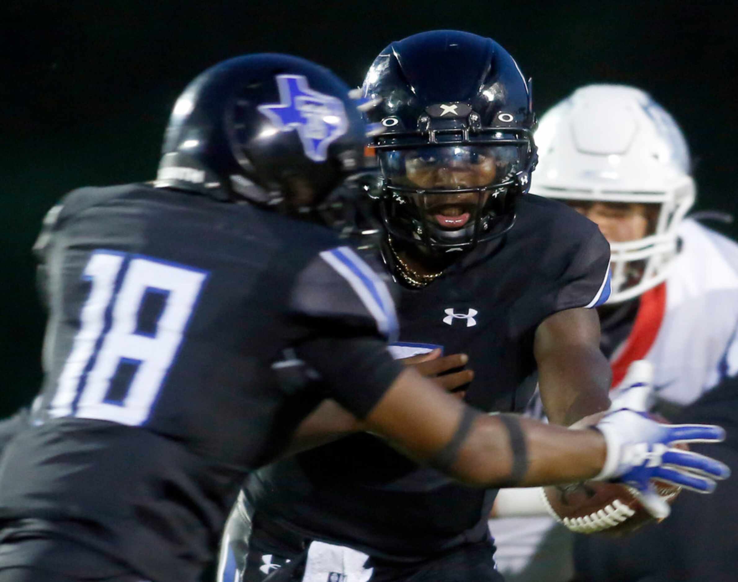 Trinity Christian Cedar Hill quarterback Shedeur Sanders (2) hands the ball off to running...