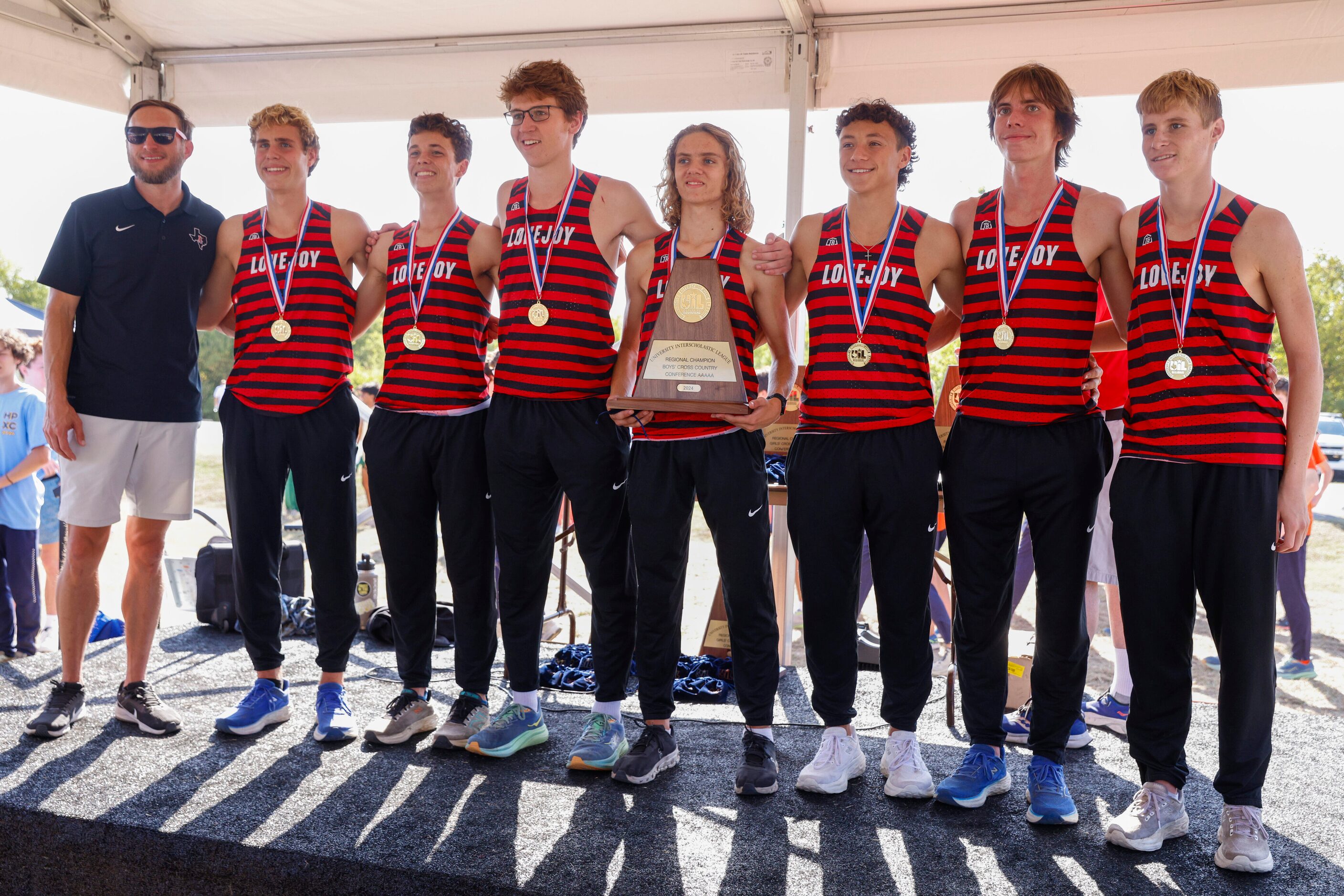 The Lucas Lovejoy boys cross country team poses for photos after winning the UIL Class 5A...