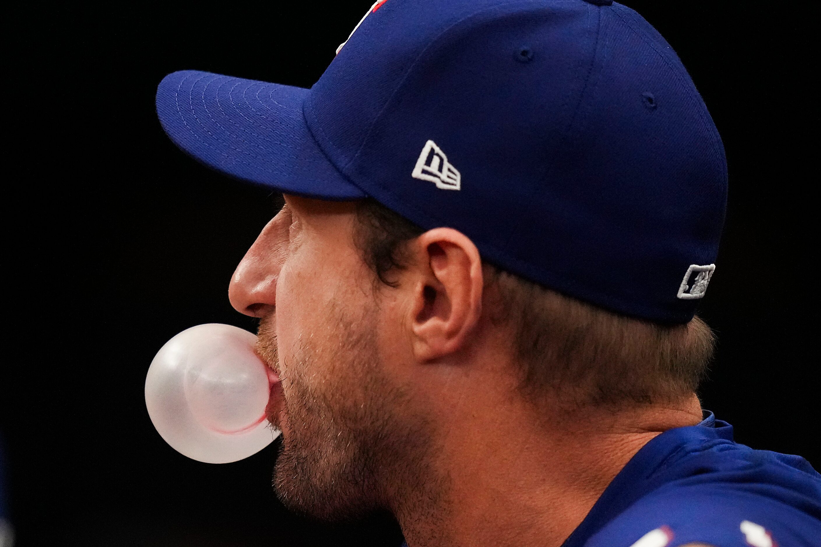 Texas Rangers pitcher Max Scherzer blows bubbles in the dugout during the second inning of...