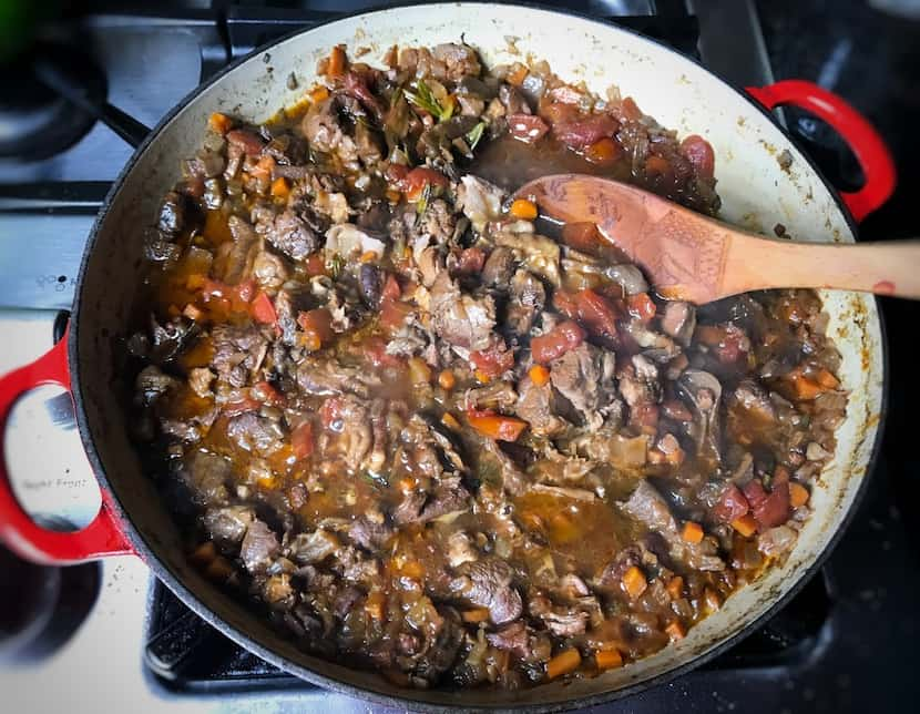 Lamb shank meat braises in red wine and broth with aromatics until the meat completely falls...