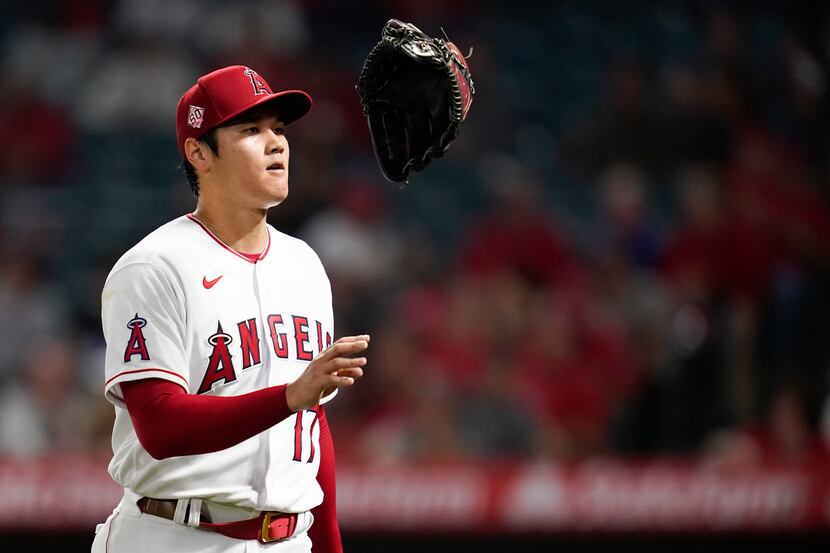 Los Angeles Angels starting pitcher Shohei Ohtani (17) tosses his glove as he returns to the...