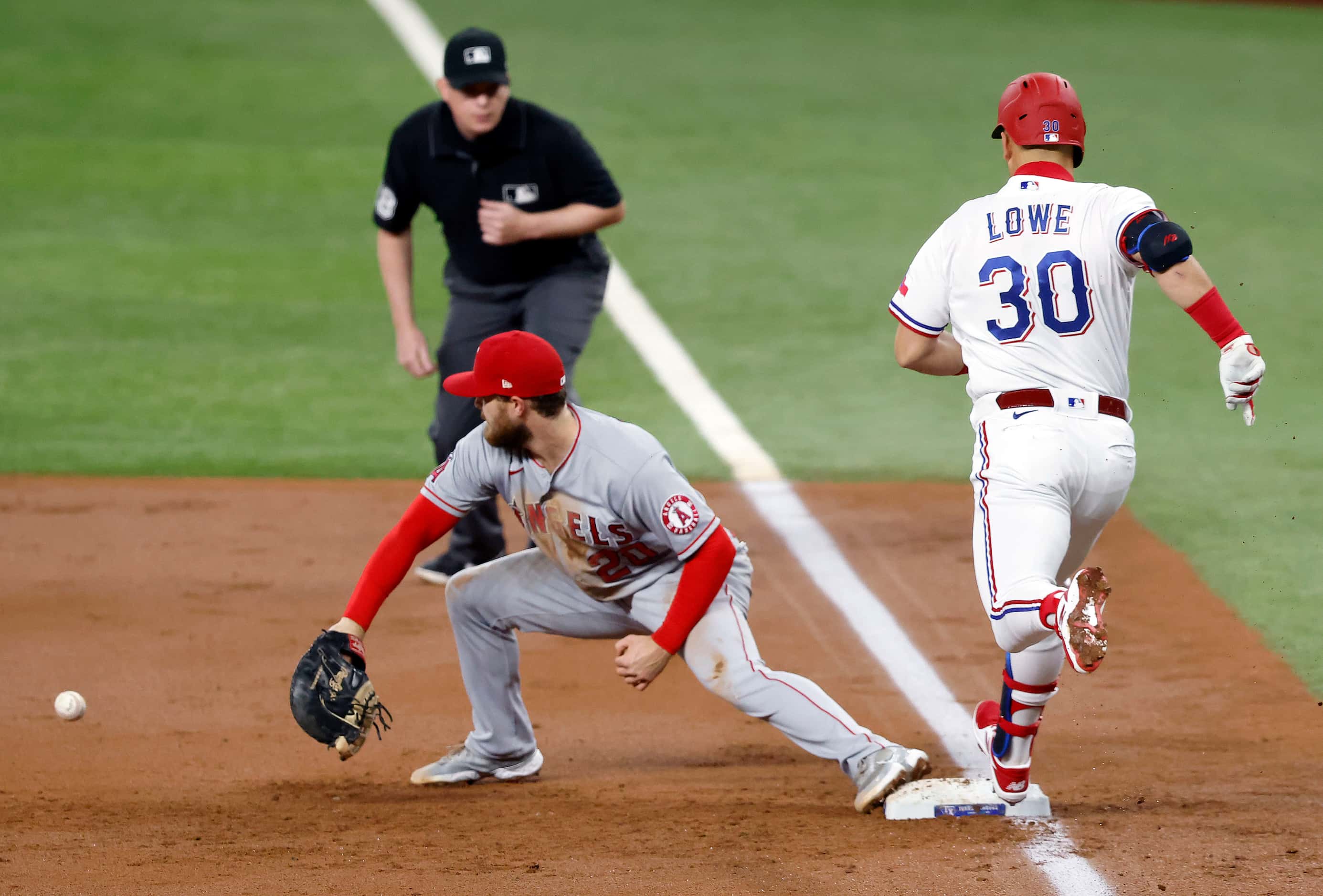Texas Rangers first baseman Nate Lowe (30) is safe at first as Los Angeles Angels first...