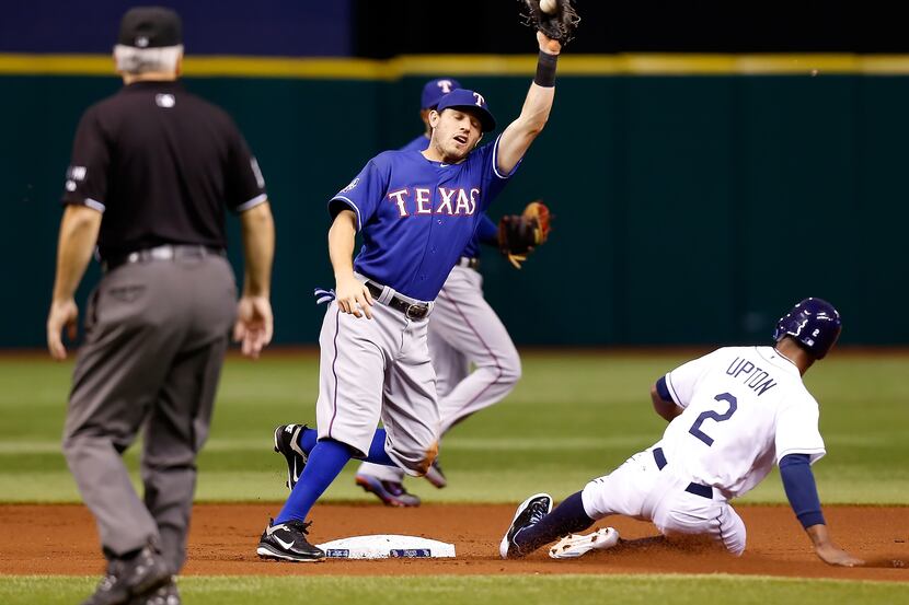 Rays outfielder B.J. Upton steals second base as Texas' Ian Kinsler gloves a high throw.