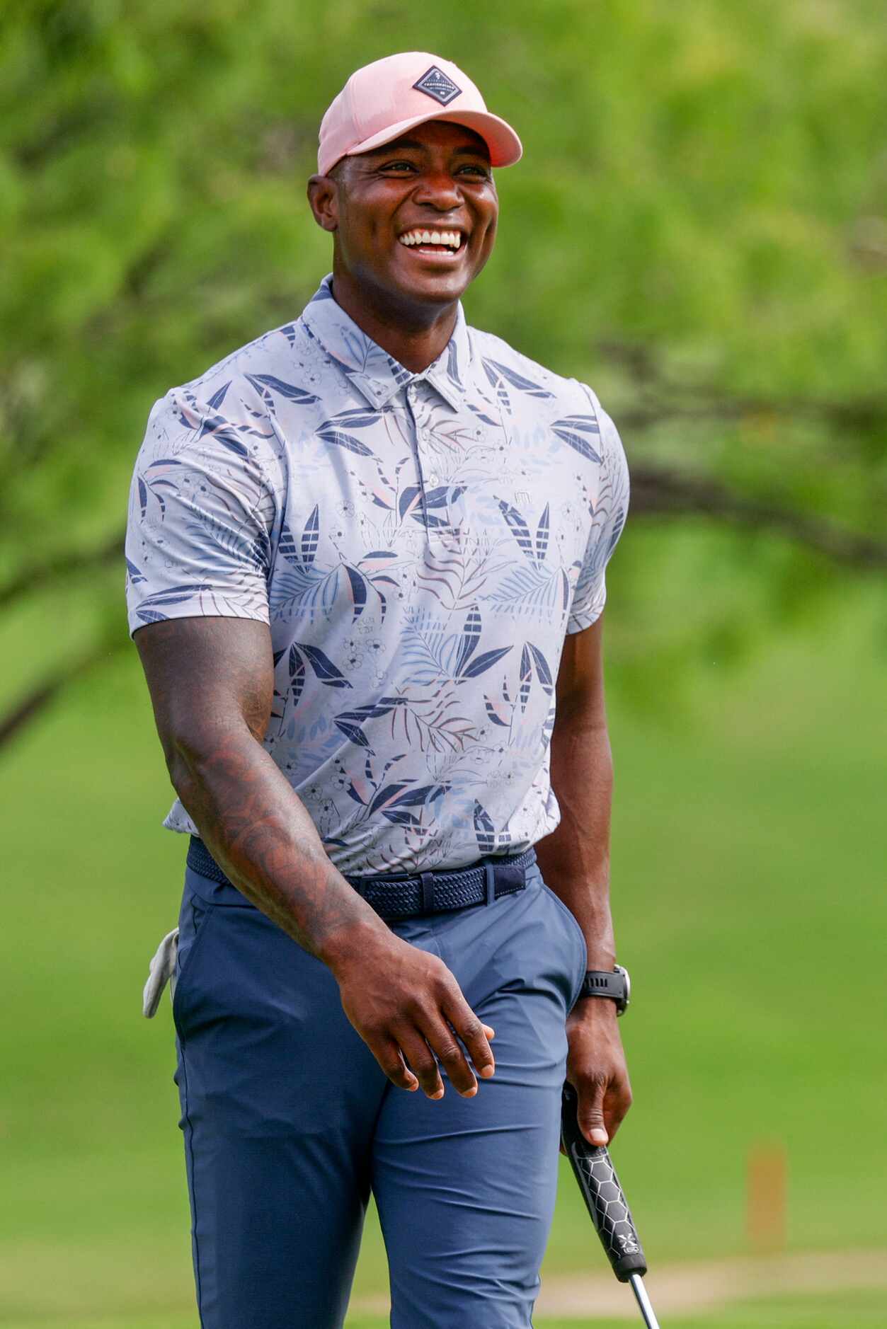 Former Dallas Cowboys player DeMarcus Ware laughs after almost putting at the same time as...