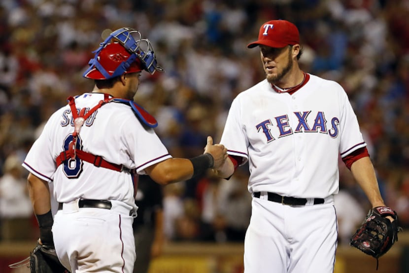 The Texas Rangers closer Joe Nathan (33) is congratulated by his team mate, catcher Geovany...