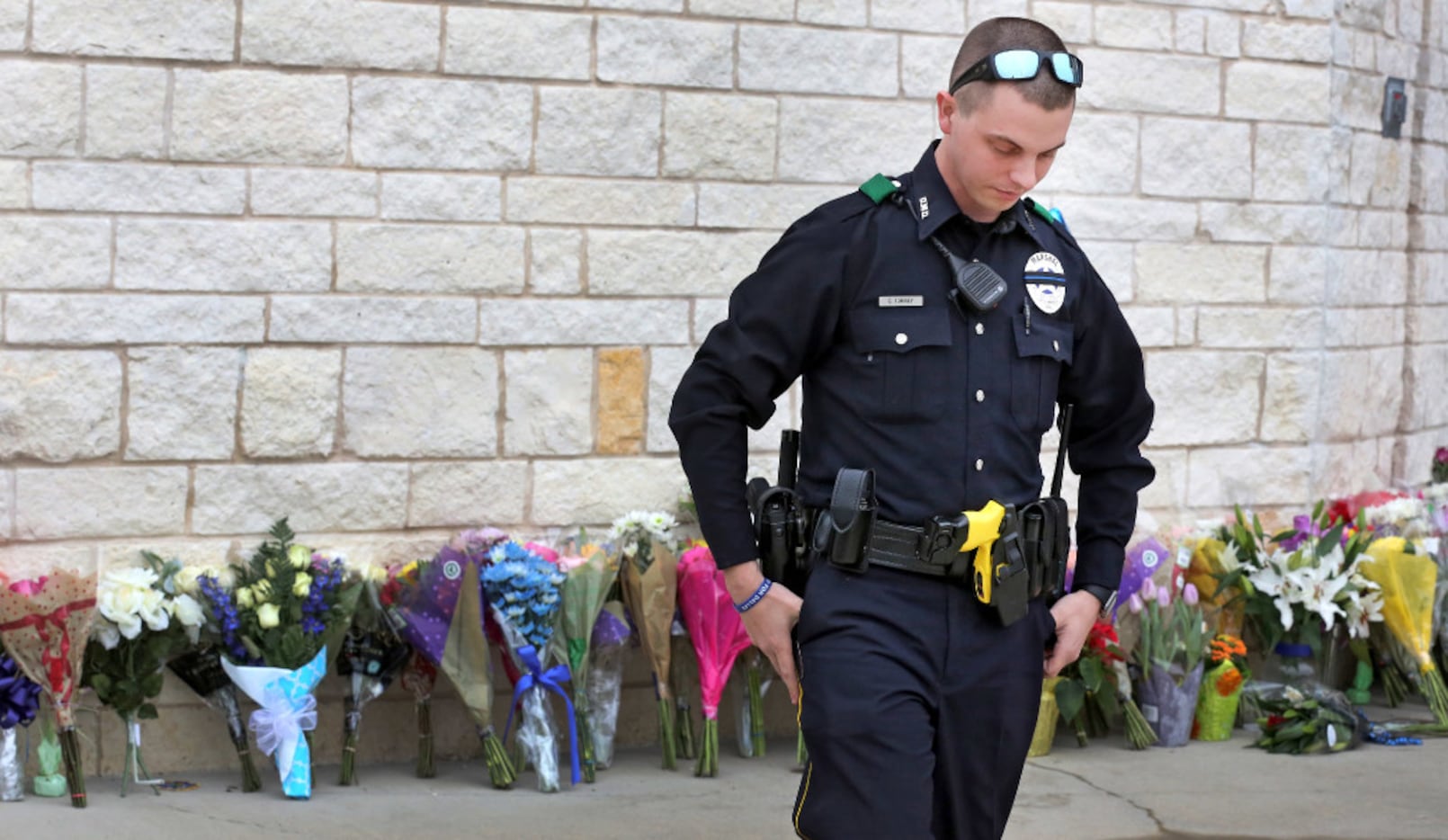 Dallas Deputy Marshal Casey Torrey spends a contemplative moment after placing a bouquet of...
