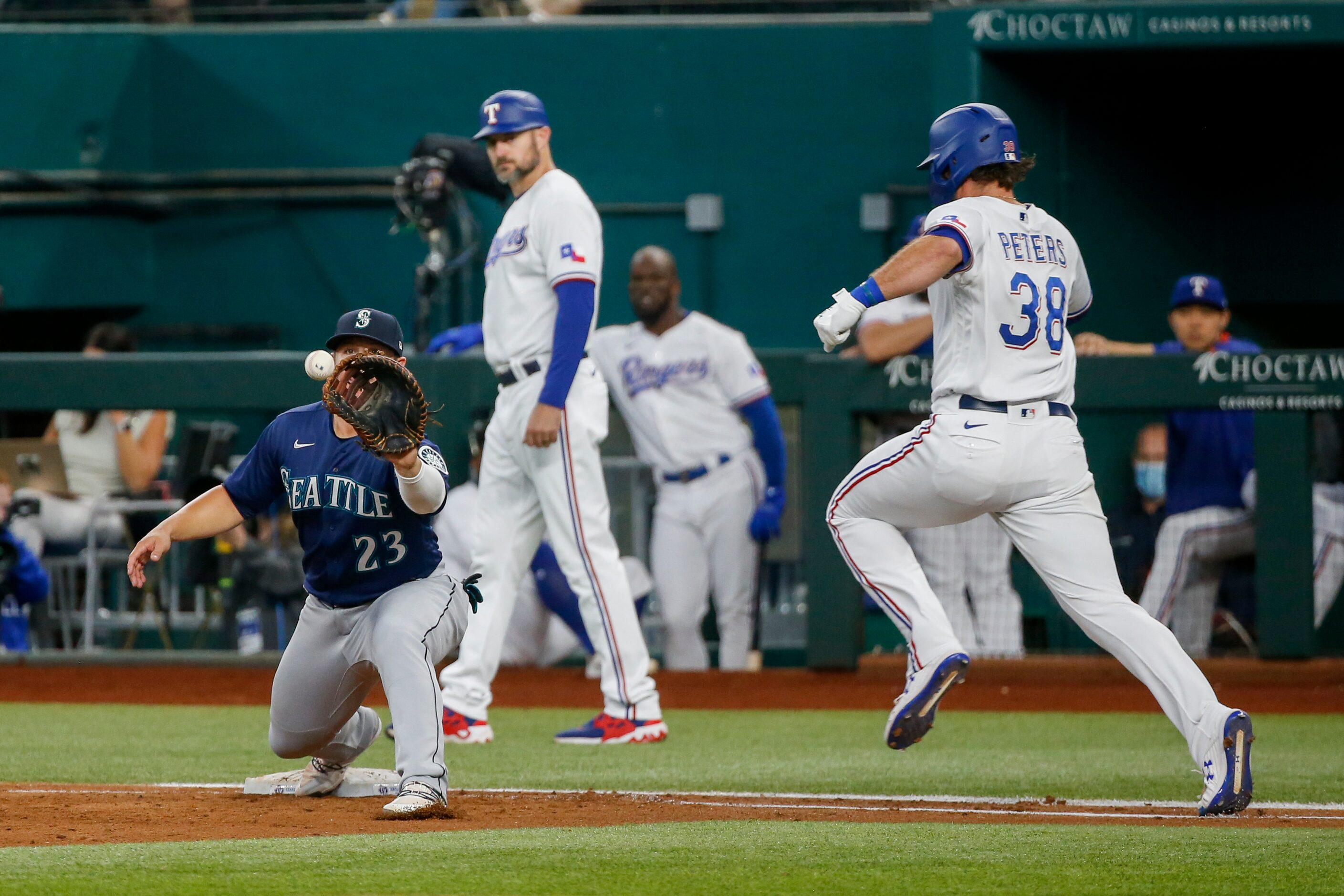 Seattle Mariners first baseman Ty France (23) catches the ball for an out ahead of Texas...