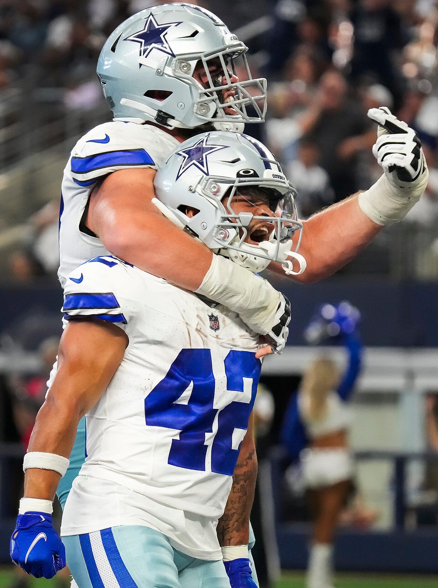 Dallas Cowboys running back Deuce Vaughn (42) celebrates with center Brock Hoffman (67)...