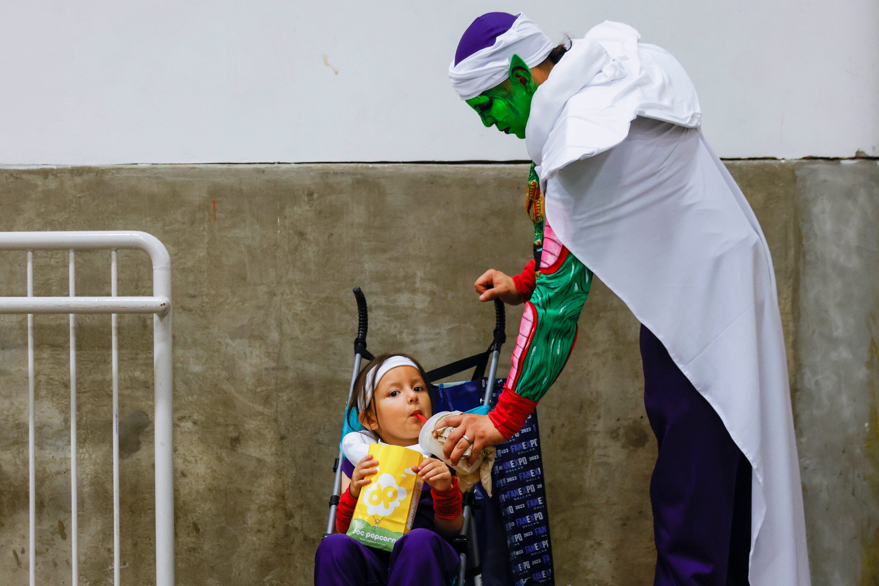 Fernando Figueroa dressed as Piccolo from Dagon Ball feeds his son Giovanni, 5, during Fan...