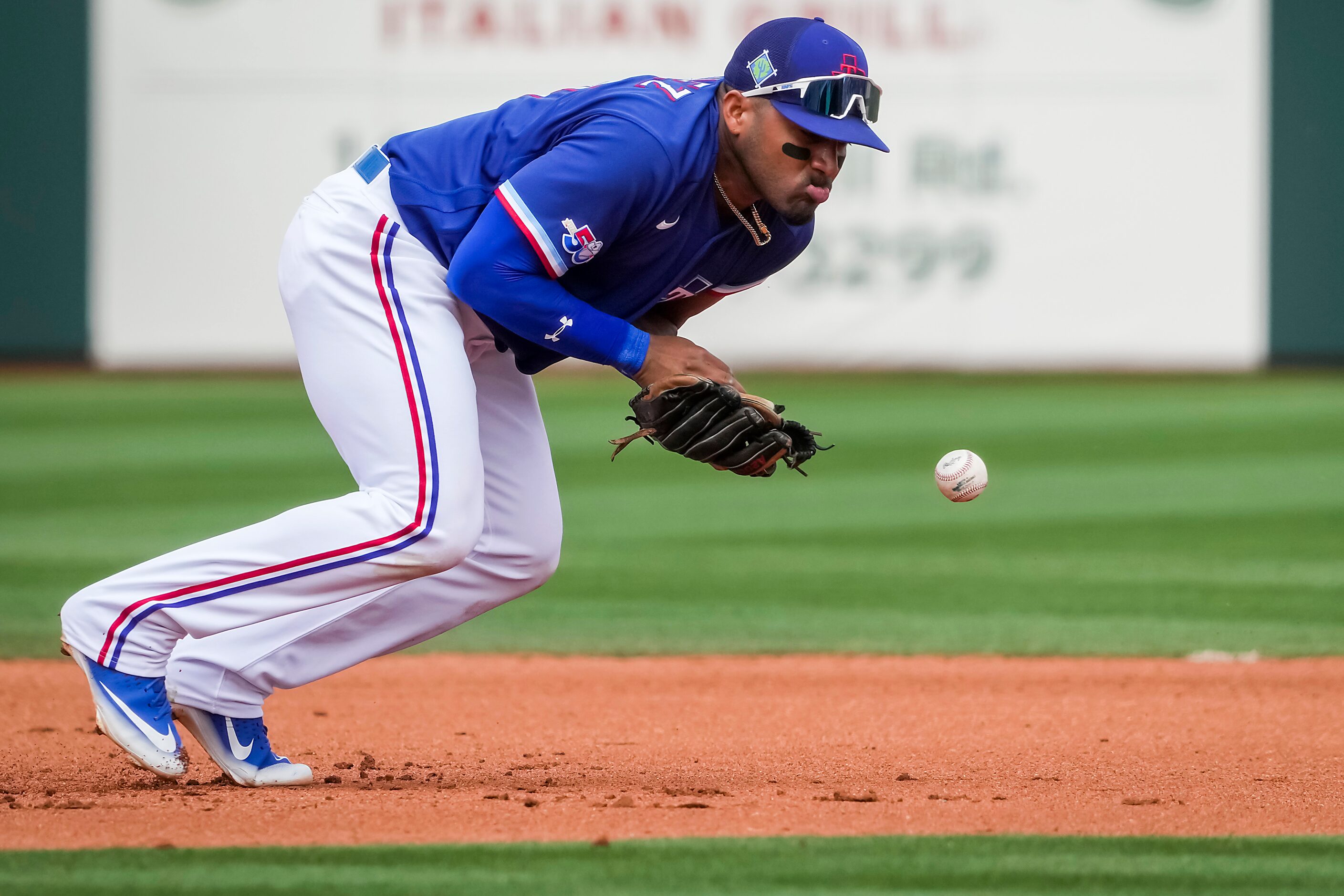 Texas Rangers third baseman Andy Ibáñez commits a fielding error allowing Milwaukee Brewers...