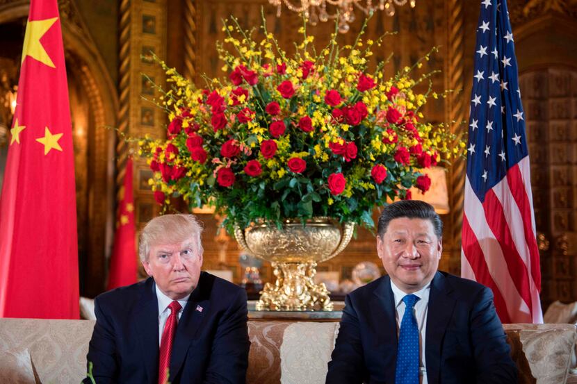 U.S. President Donald Trump sits with Chinese President Xi Jinping during a bilateral...