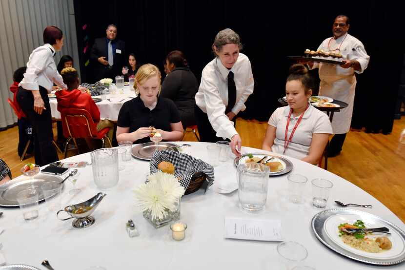 Dylan Holbert, 14, left, and Haley Alaniz, 13, are served their main dish from waitress...