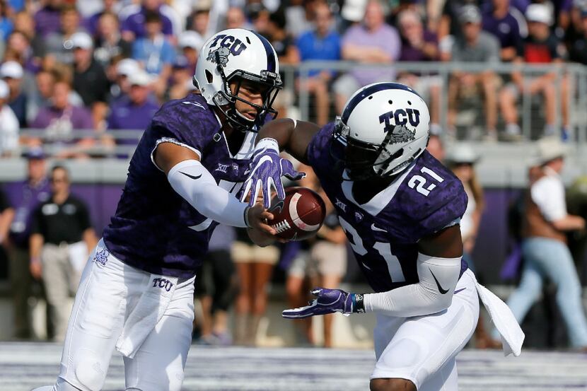 FILE - In this Oct. 29, 2016, file photo, TCU quarterback Kenny Hill, left, hands the ball...