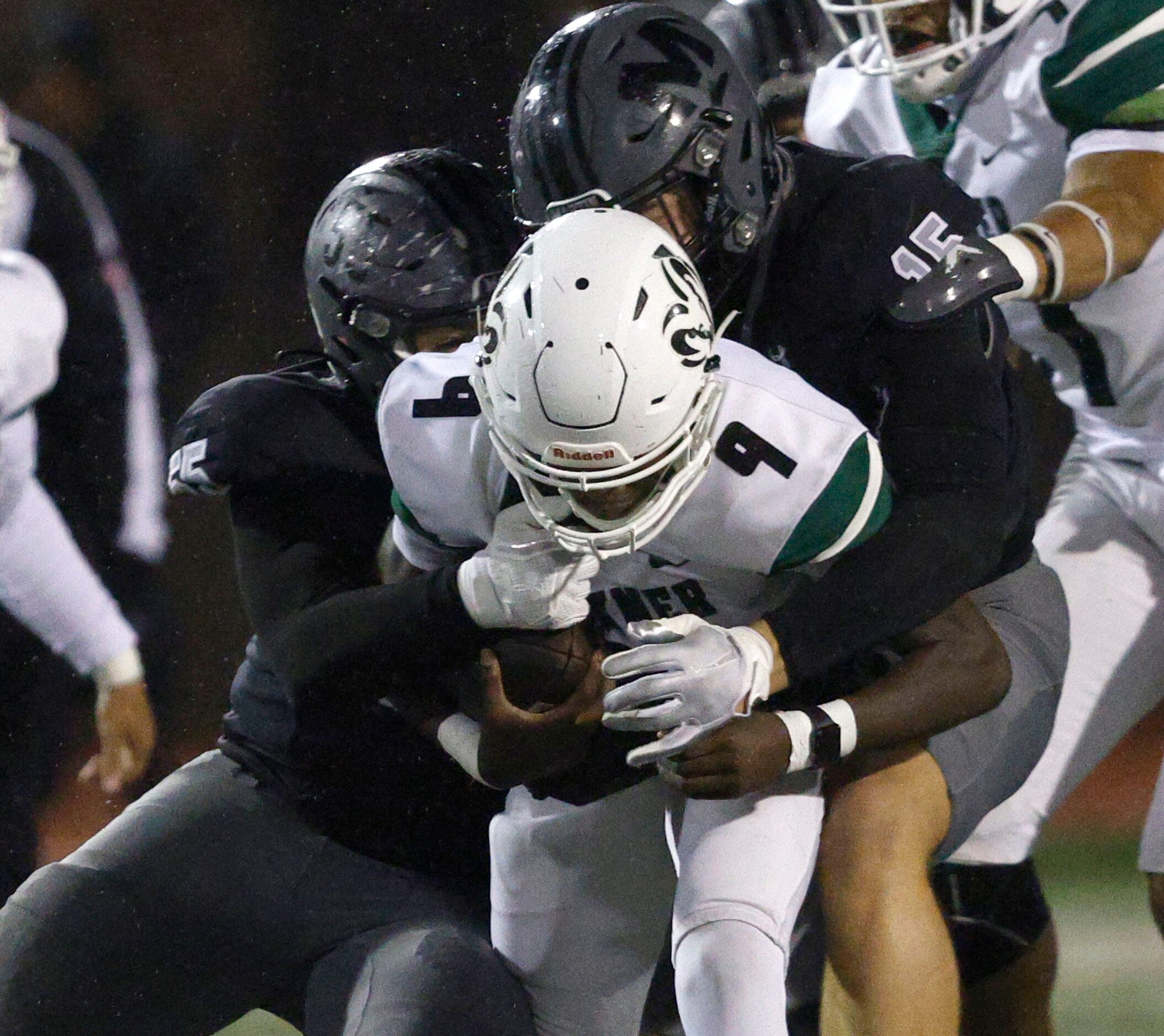 Berkner's Daquan Dunn (9) is tackled by Martin's Joseph Jubain (55) and Martin's Jesse Ford...