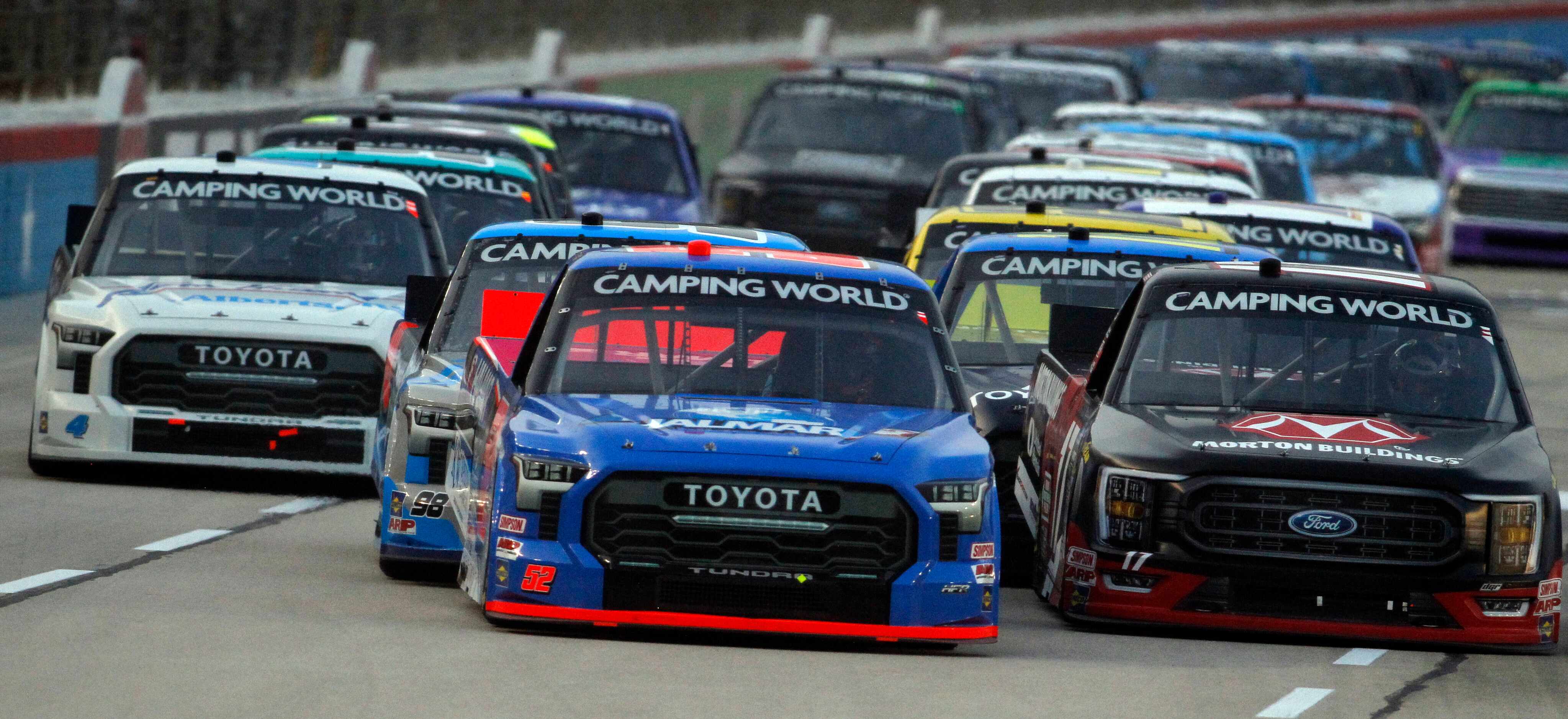 Driver Stewart Friesen, in Halmar International Toyota (#52), center, leads the pack out of...