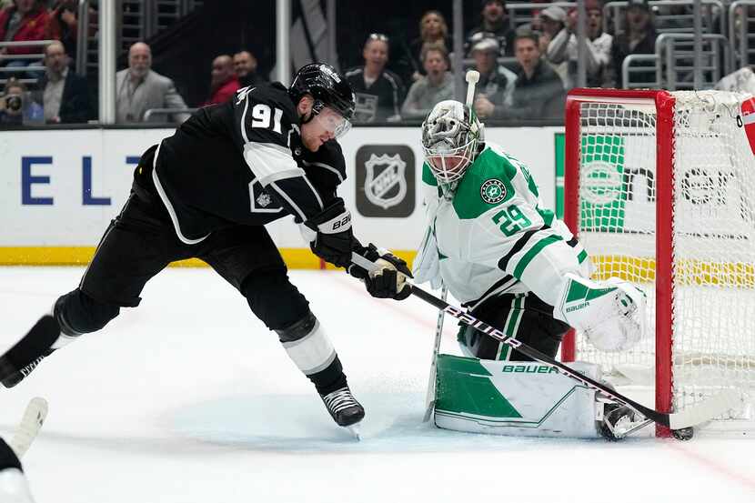 Los Angeles Kings right wing Carl Grundstrom, left, tires to get a shot past Dallas Stars...