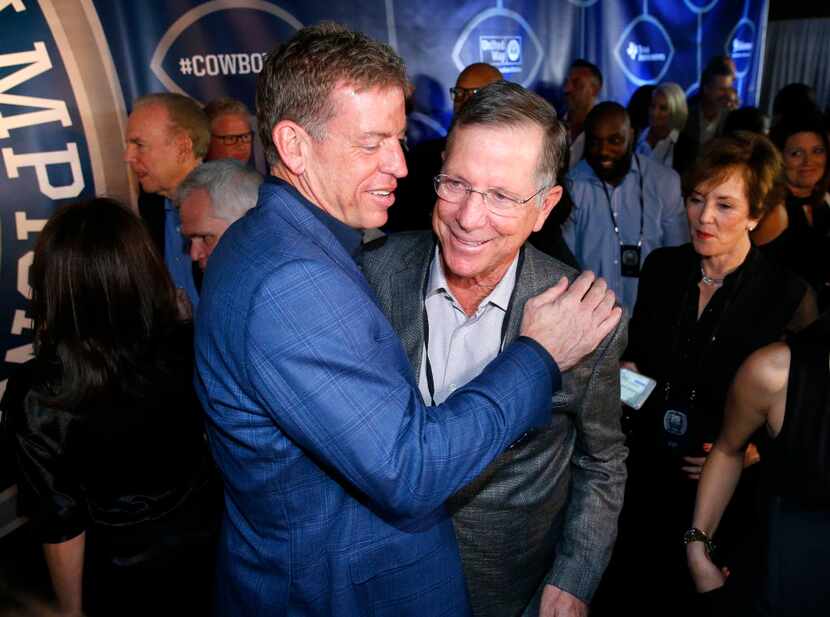Former Dallas Cowboys football player Troy Aikman gives a hug to offensive coordinator Norv...