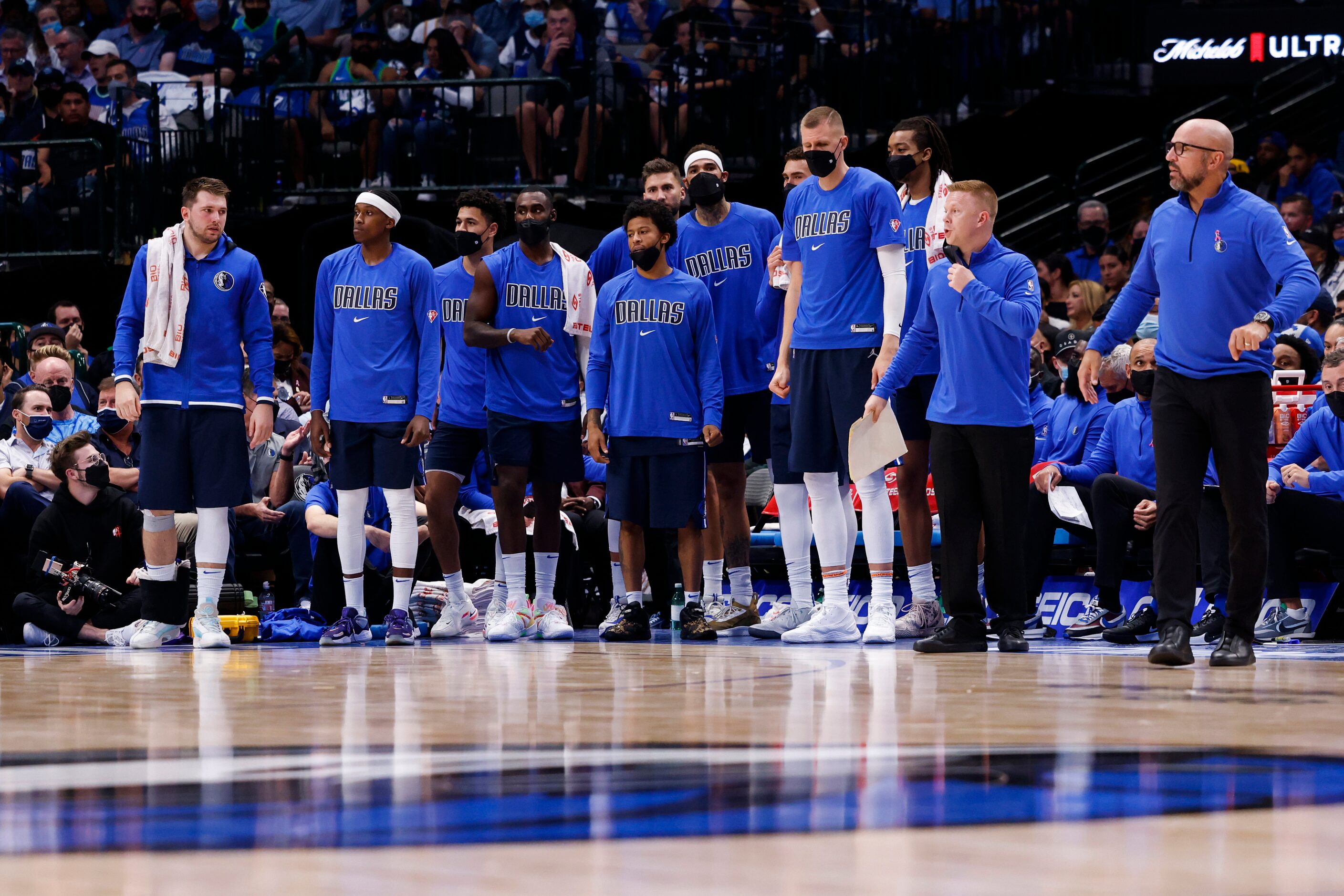 The Dallas Mavericks watch during the fourth quarter of their home opener against the...