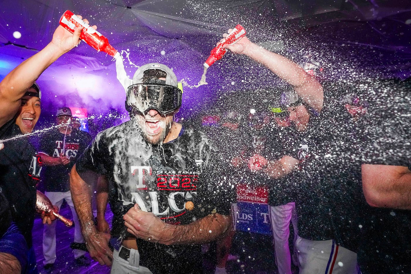Texas Rangers starting pitcher Nathan Eovaldi is doused with beer and champagne as he...