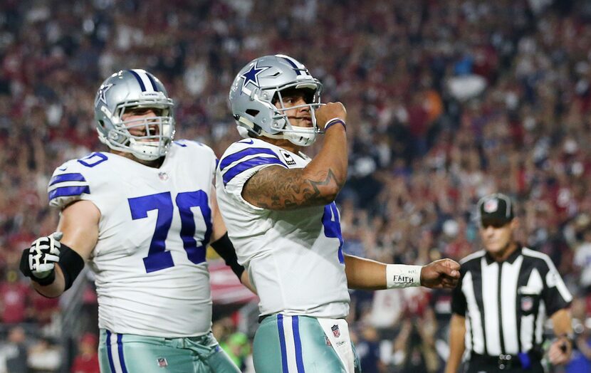 Dallas Cowboys quarterback Dak Prescott (4) celebrates with offensive guard Zack Martin (70)...