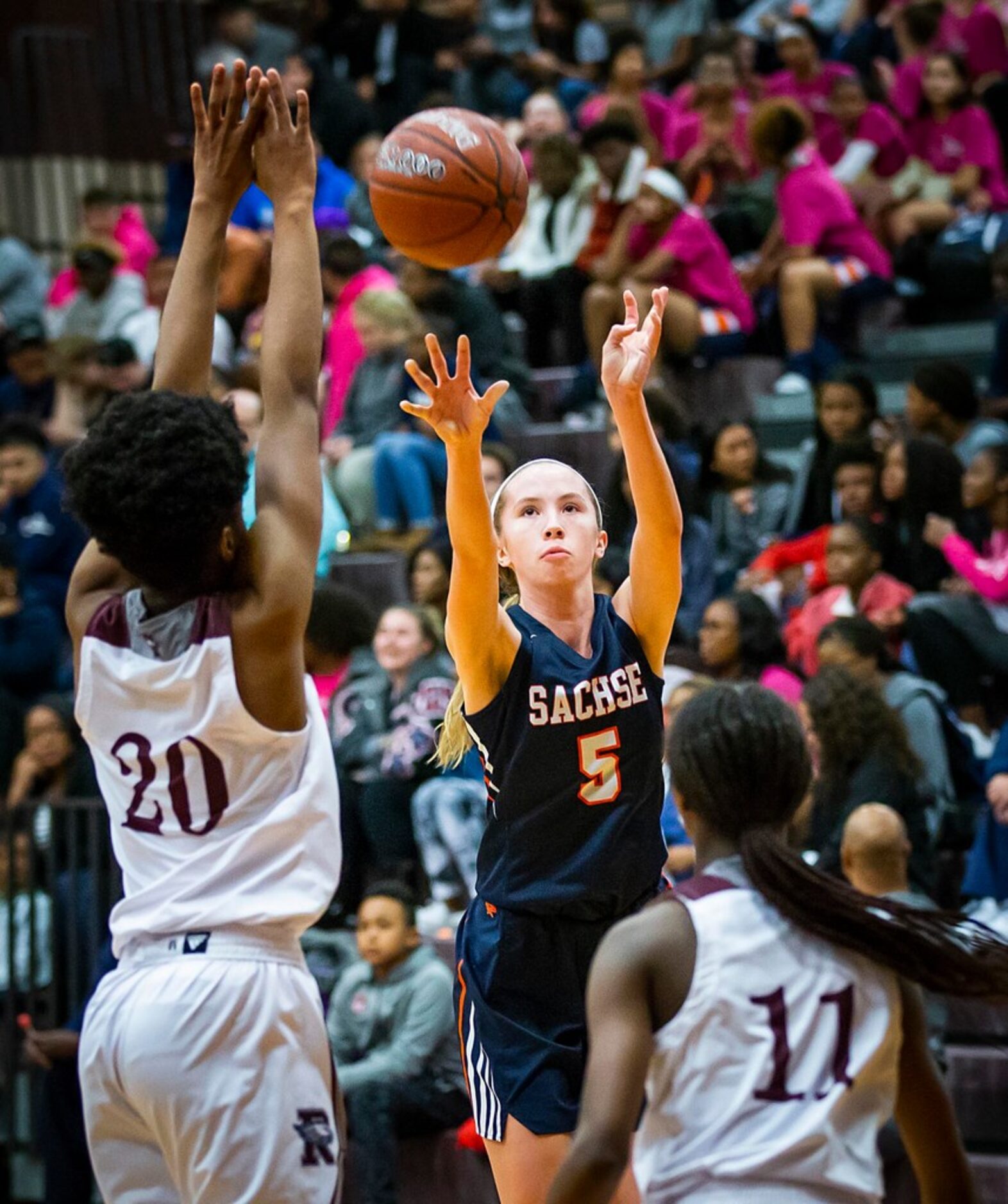 Sachse guard Avery Crouse (5) shoots a 3-pointer over Rowlett's Ngozi Obineke (20) and...