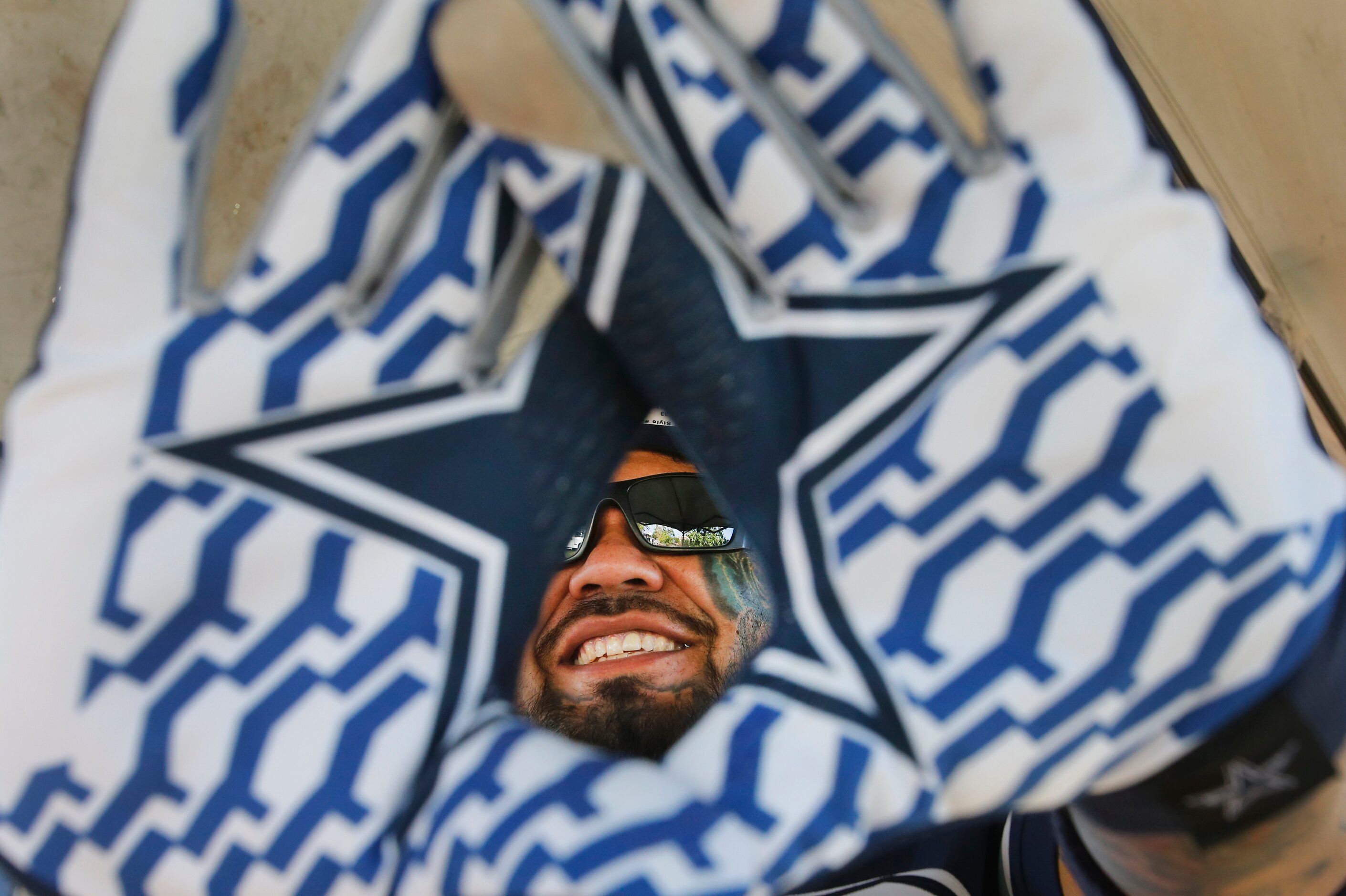 Cowboys fan Mickey Benitez wears his Cowboys gloves as he tailgates with friends before the...