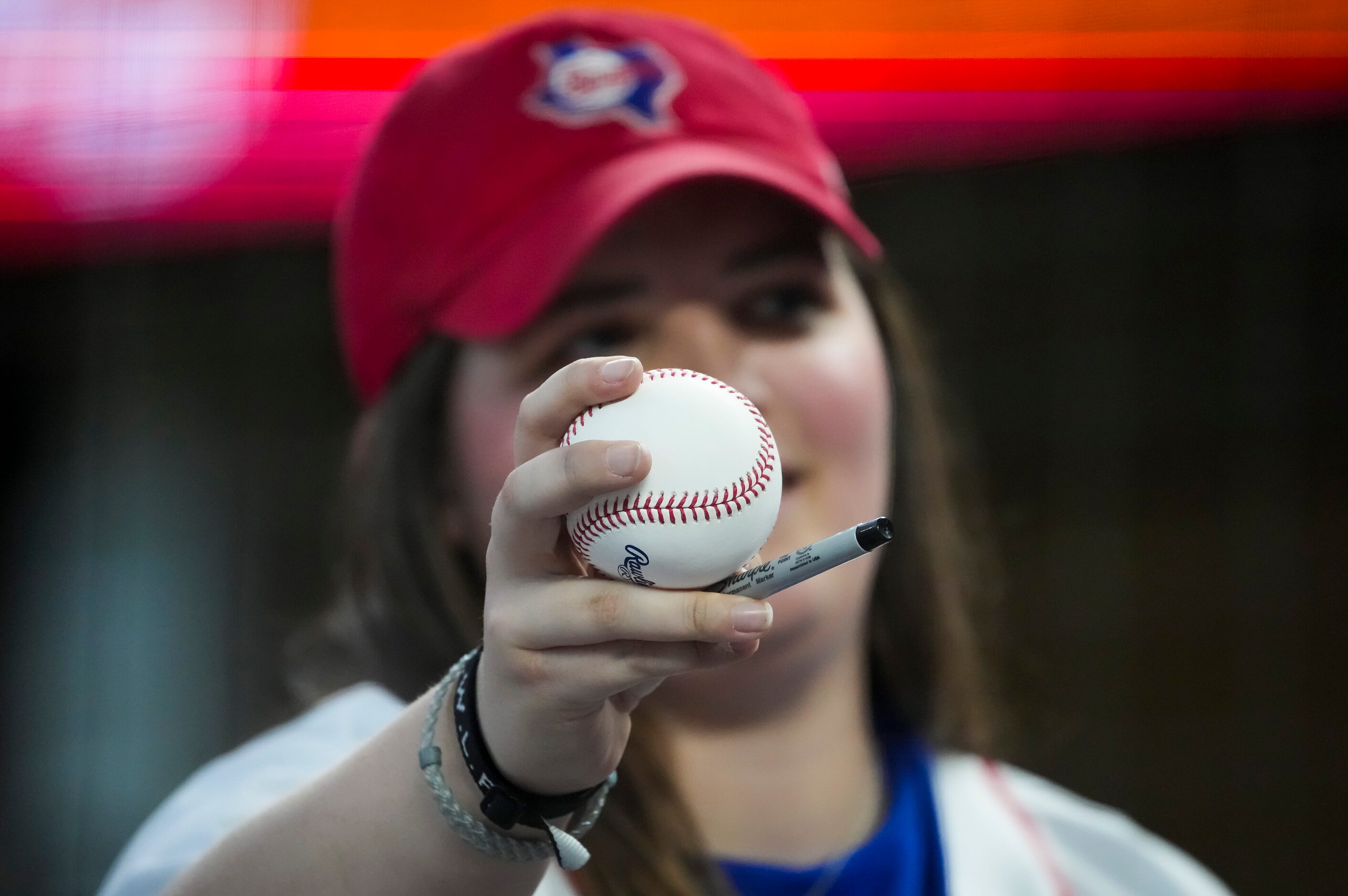 A Texas Rangers fan tries to get an autograph during batting practice before the team’s home...