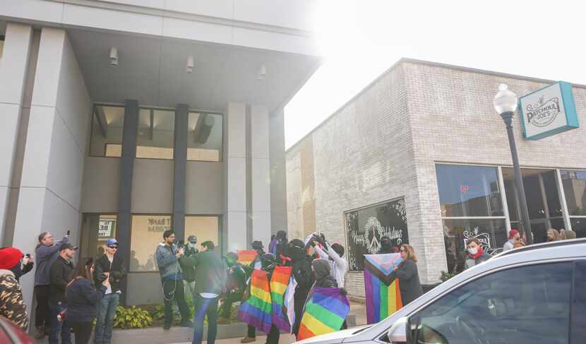 Protesters (left) approach counterprotesters holding LGBT flags outside of Patchouli Joe's...