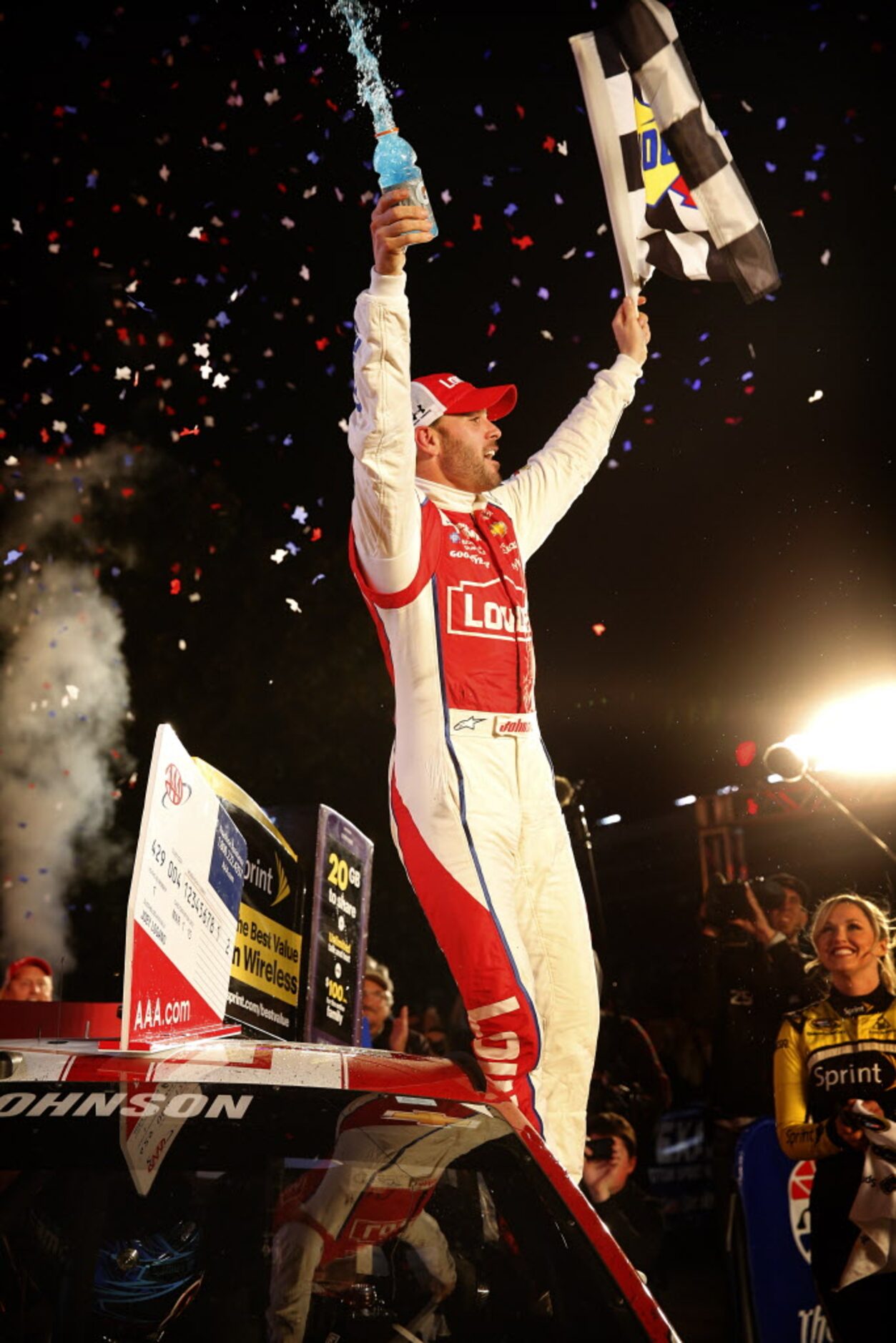 Sprint Cup Series driver Jimmie Johnson (48) stands on his car window as he celebrates his...