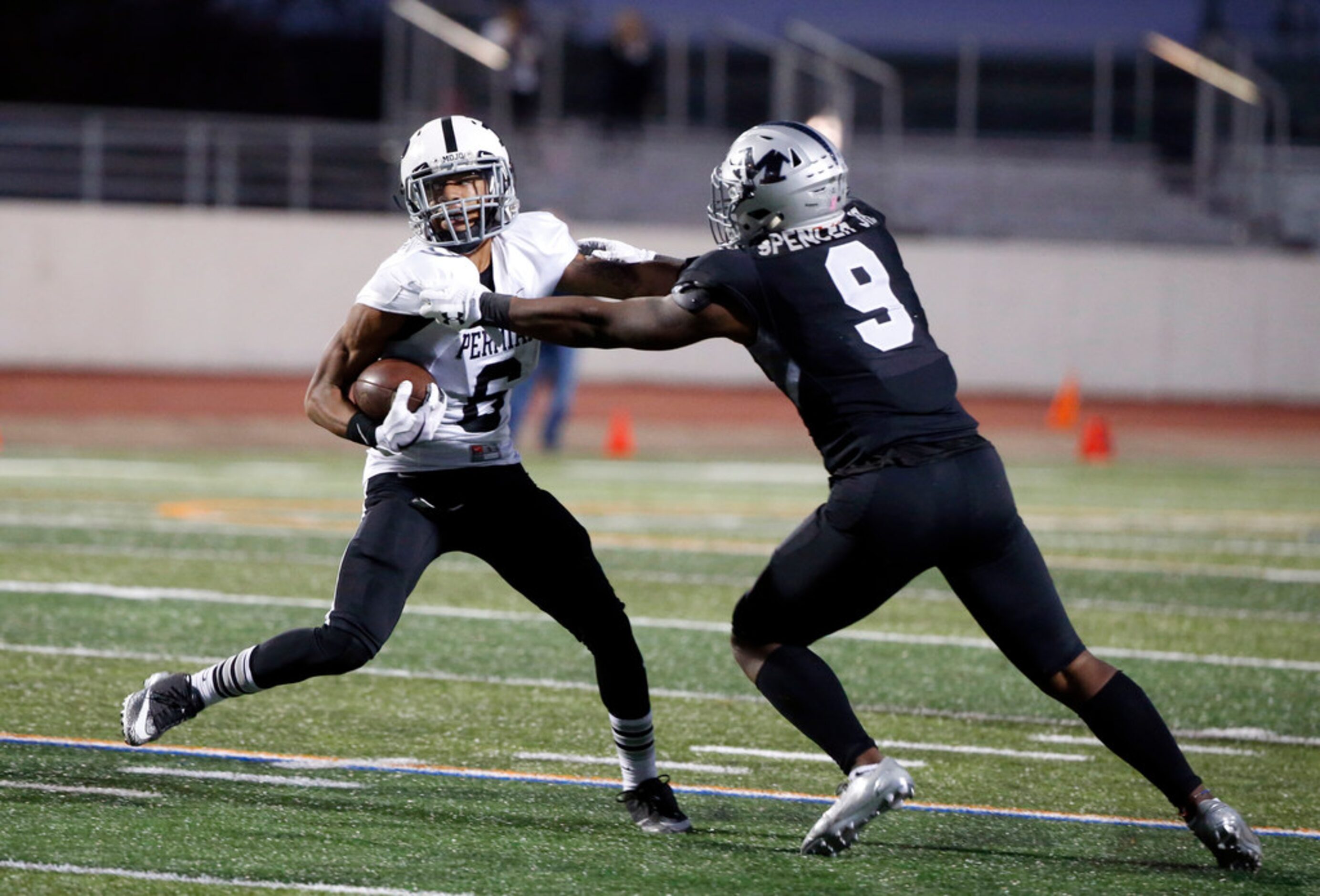 Odessa Permian's Keshawn Jones (6) is tackled by Arlington Martin's Kelvin Spencer (9)...