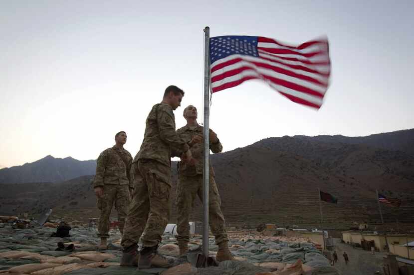 Capt. Erik Schutz, 26, and Capt. Matt Schachman, 28, raise a new American flag to...