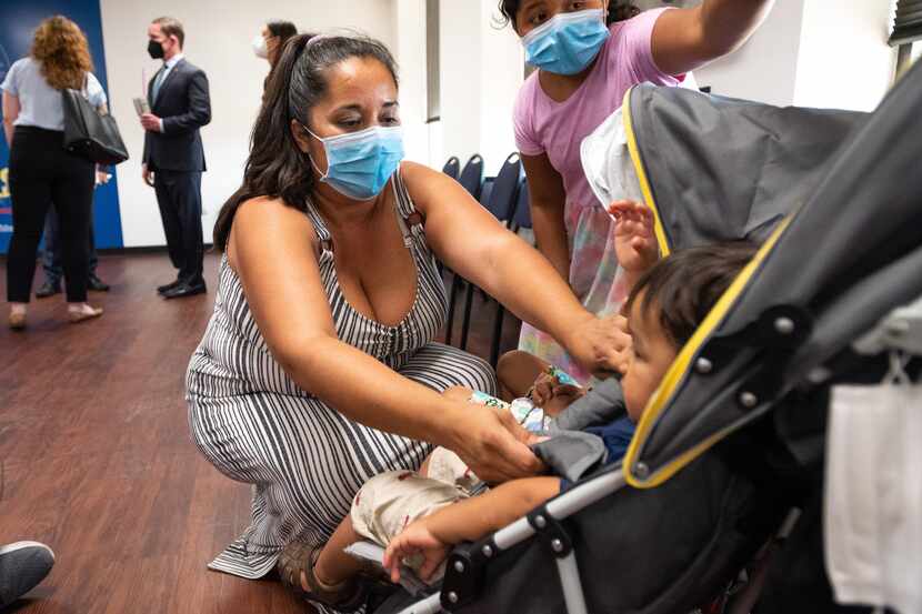 Alice Juarez straps her 22-month-old son, Daniel Juarez, into a stroller before rolling him...